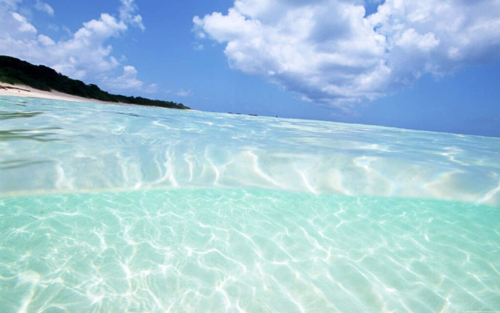 Tranquil Ocean Wallpaper: Bright Blue Water & Fluffy Clouds Background