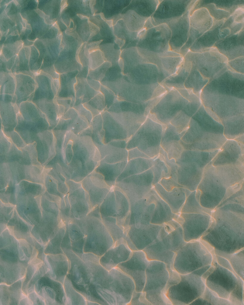 Serene Ocean Water: Gentle Waves & Sunlight Reflection Background Wallpaper