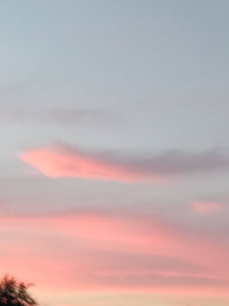 Serene sunset sky with pastel pink and orange wispy clouds perfect for calming wallpaper