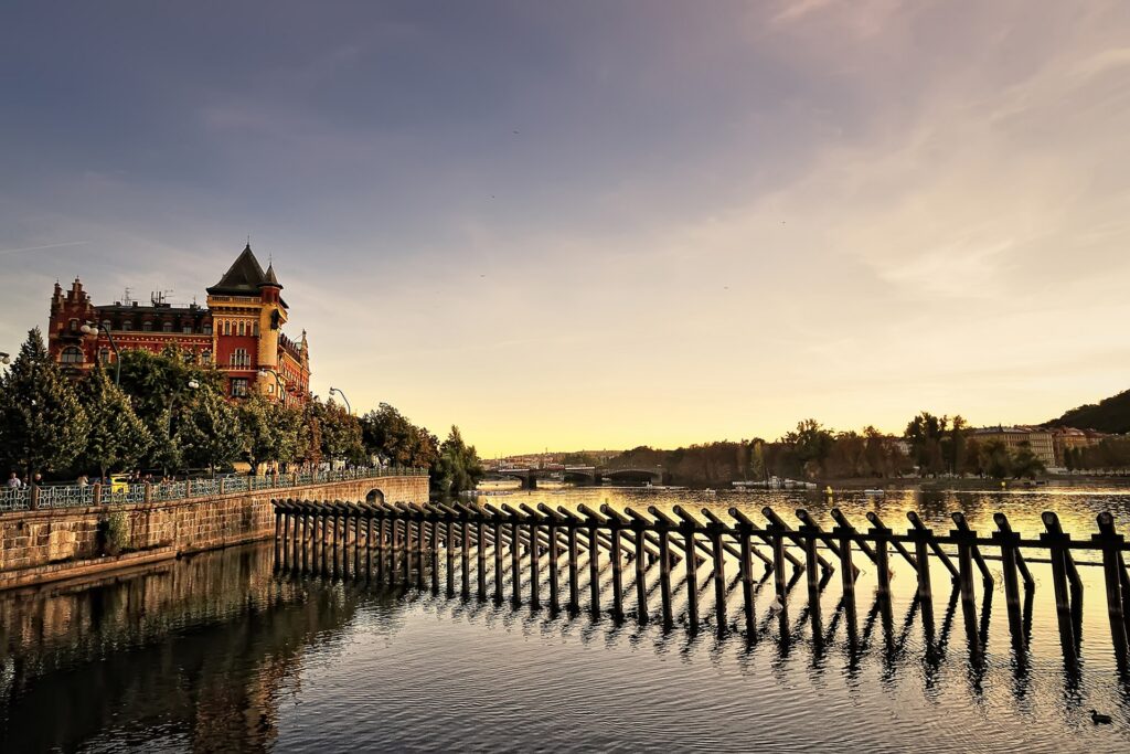 Scenic Prague Wallpaper: Serene Riverside Sunset & Historic Charm