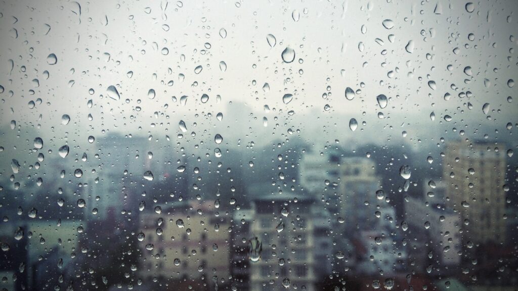 Calming Raindrop Wallpaper: Serene Windowpane & Blurred Cityscape