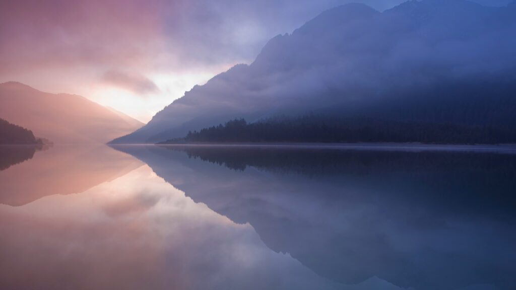Serene macOS High Sierra 5K wallpaper mountain range forest reflected in calm lake at dawn
