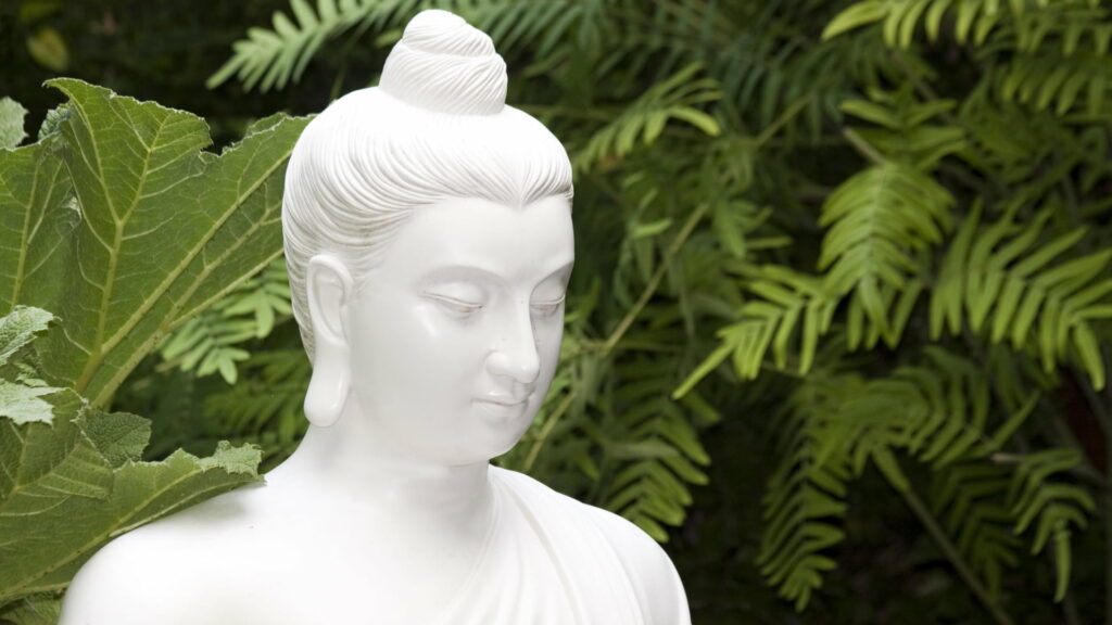 Serene Enlightenment: A High-Resolution Image of a Majestic Buddhist Sculpture Wallpaper