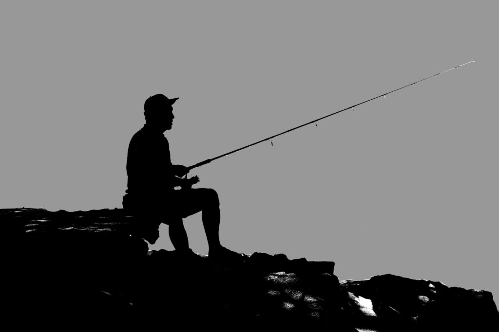 Tranquil Waters: Serene Fisherman on Seashore Wallpaper