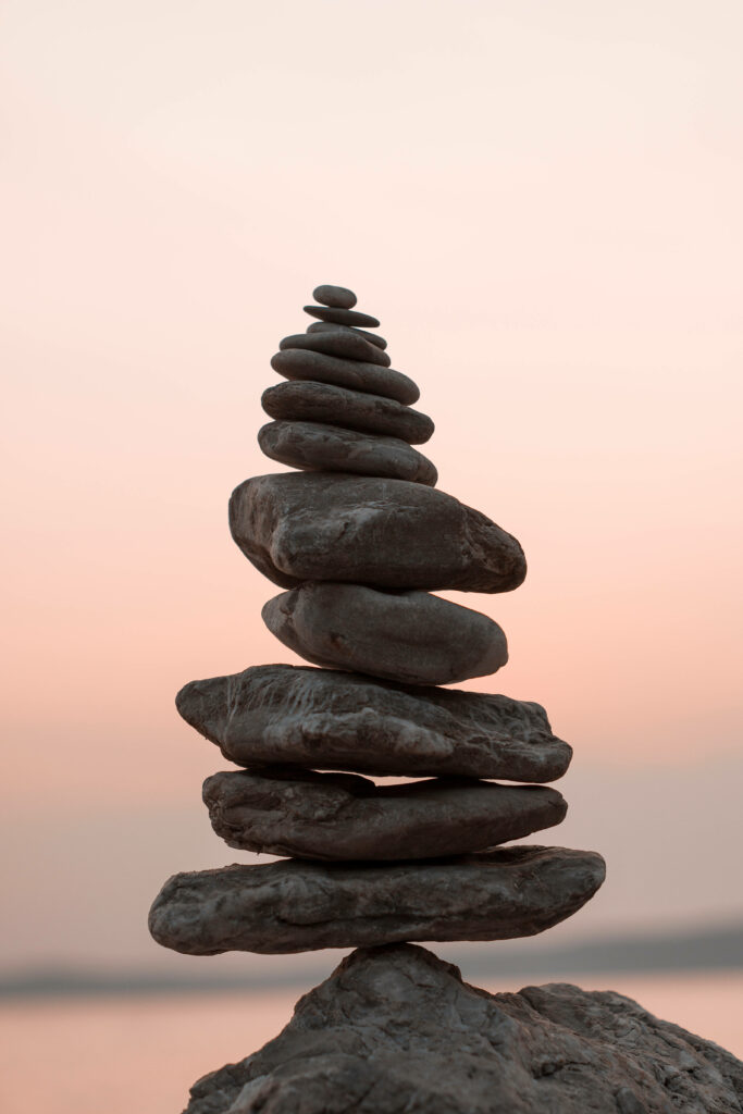 Tranquil Wallpaper: Serene Stacked Rocks Against Pastel Sky