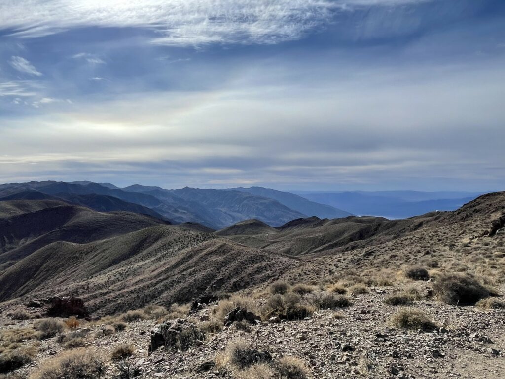 Breathtaking wallpaper of rolling hills rugged mountains with bushes stones under dramatic sky