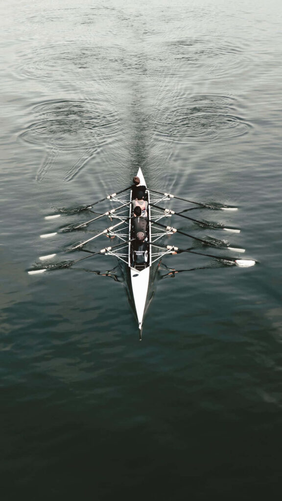 Tranquil Wallpaper: Rowers in Synchronized Harmony on Calm Water