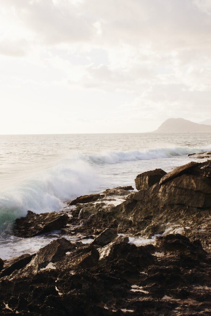 Rugged coastline with crashing sea waves and golden sky natural textured seascape wallpaper