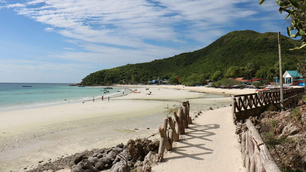 Serene Sandy Beach Wallpaper: Turquoise Waters & Lush Green Hills