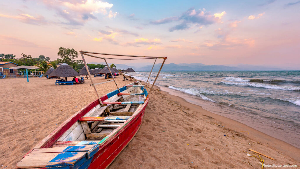 Tranquil Sandy Shoreline Wallpaper with Colorful Boat - Serene Scene