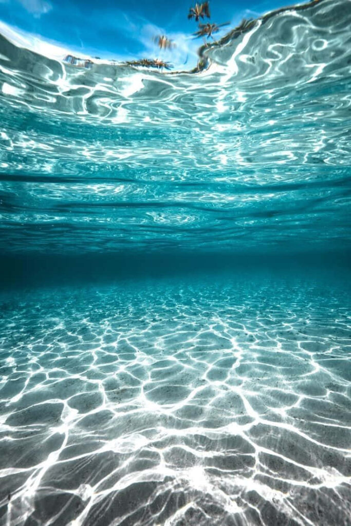 Serene Sea Sunlight Wallpaper: Patterns on Sandy Ocean Floor