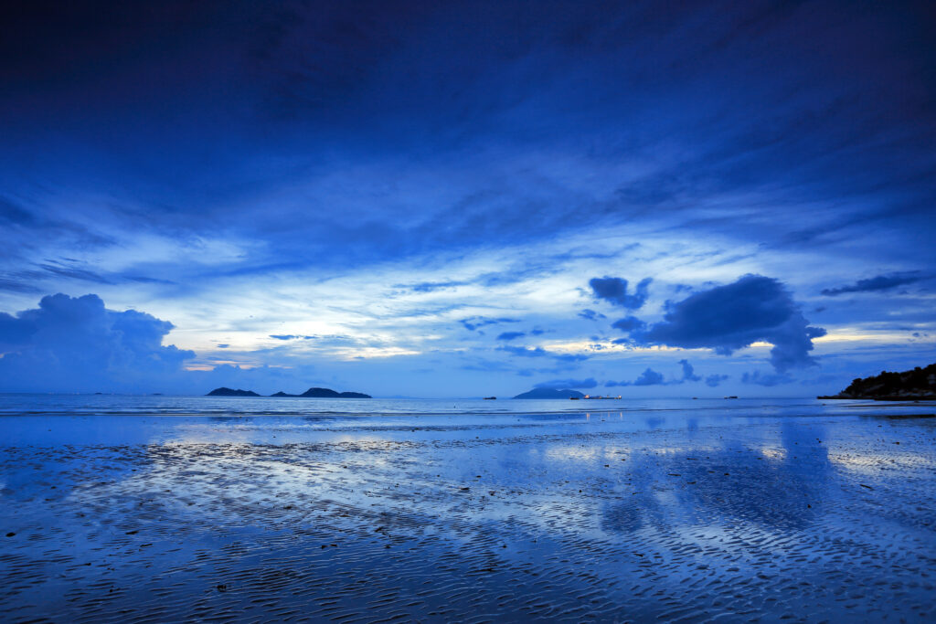 Serene seascape wallpaper with tranquil water reflecting blue sky and soft clouds at horizon