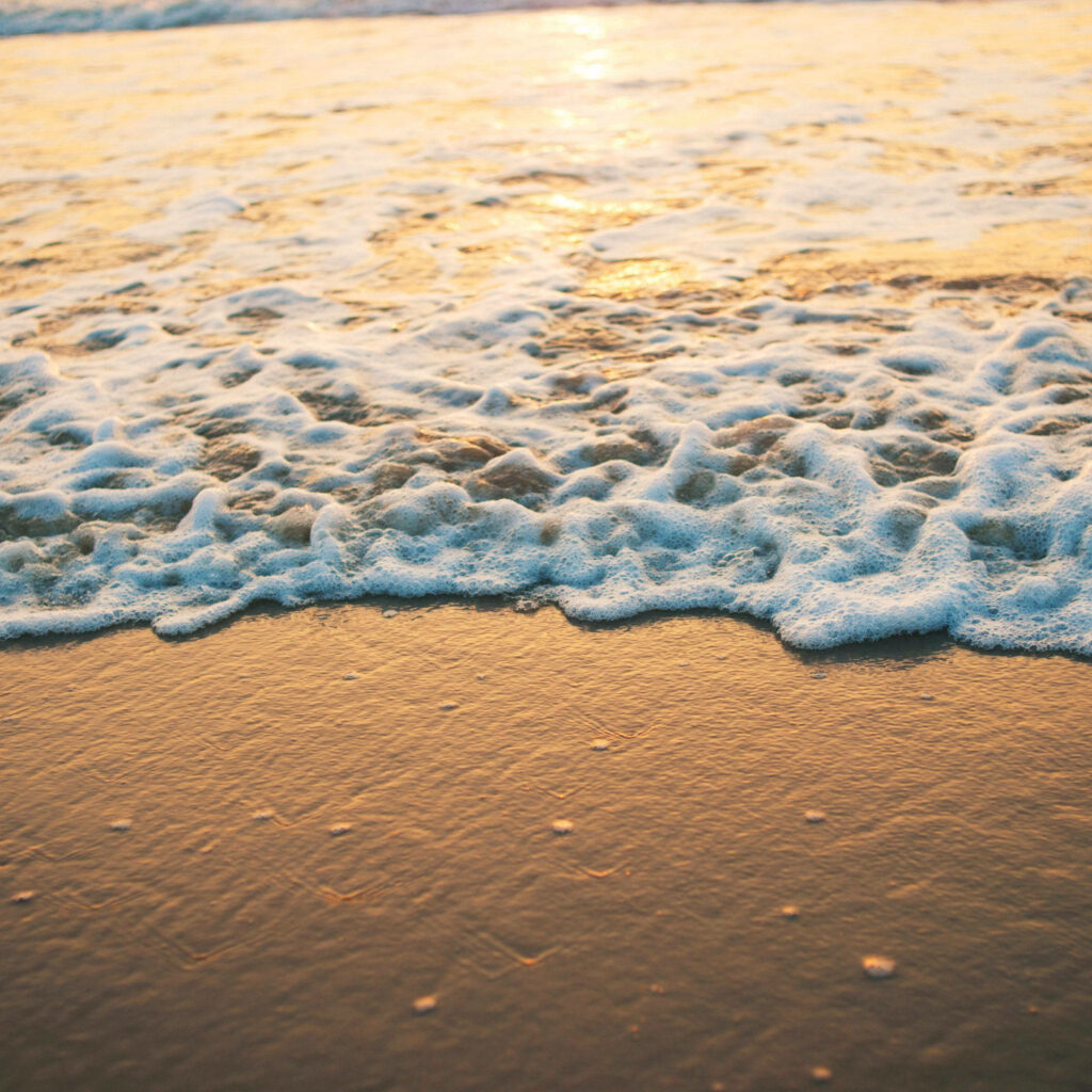 Serene Seaside Sunset Wallpaper: Gentle Waves & Golden Light Background