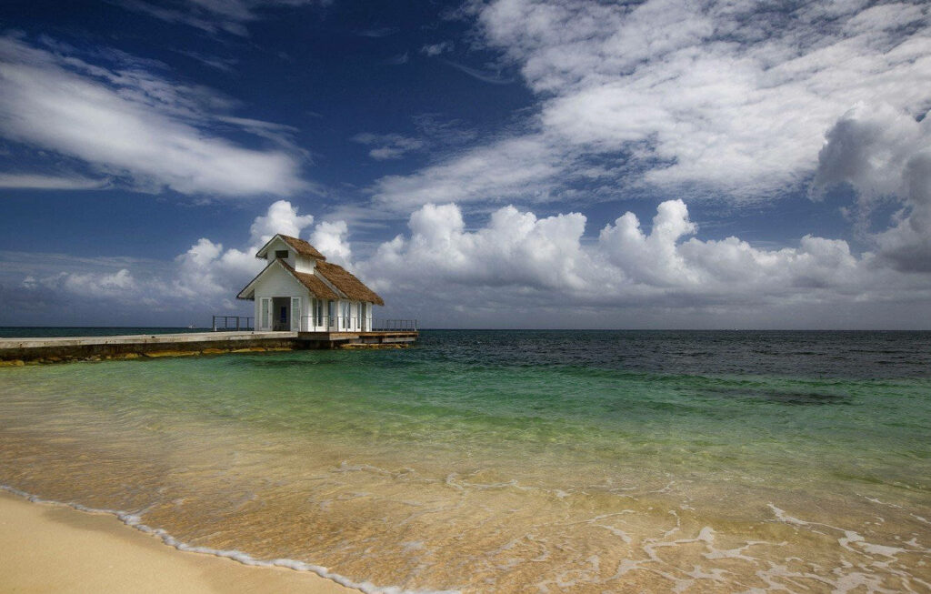 Serene Seaside Wallpaper: Tranquil House on Pier with Turquoise Waters