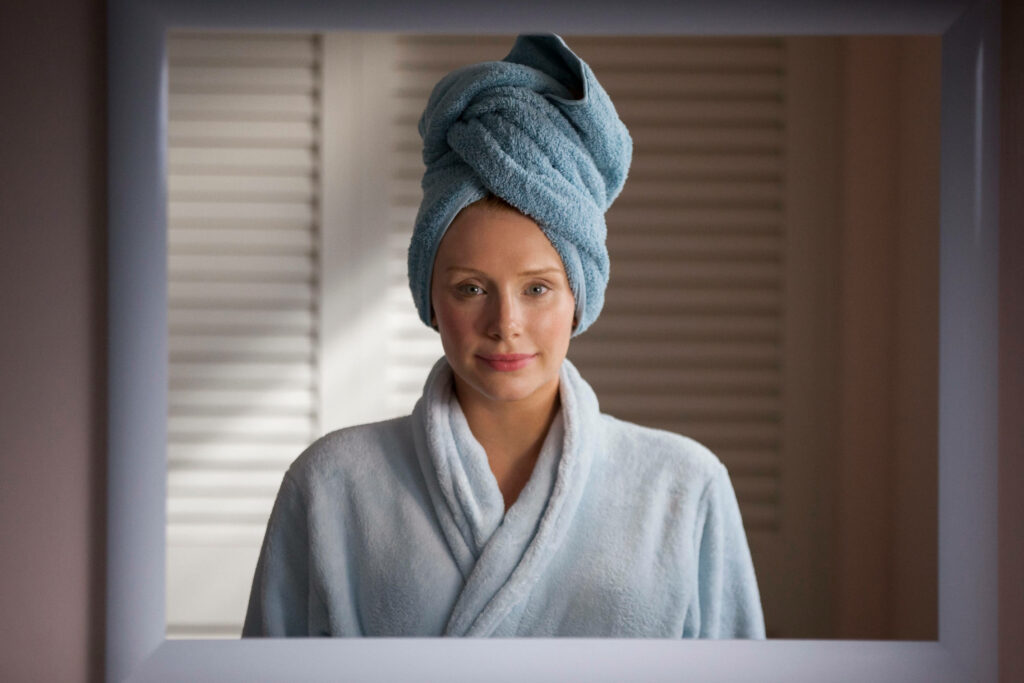 Serene Reflection: Woman in Bathrobe & Towel in Black Mirror Wallpaper