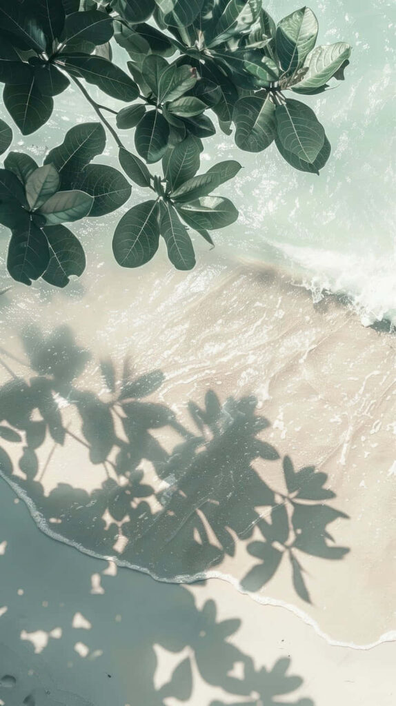Tranquil Shoreline Wallpaper: Soft Waves & Lush Green Leaves
