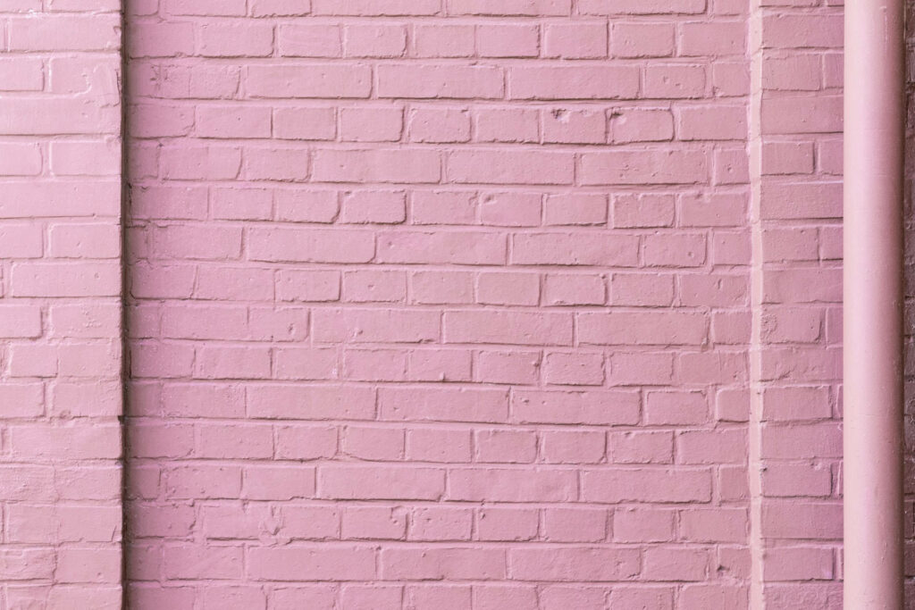 Blushing Brick: A Serene Pastel Pink Wall to Set the Background Wallpaper