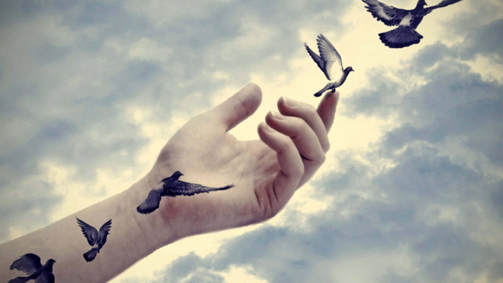 Serene Sky Wallpaper: Tattoo-Style Birds & Outstretched Hand
