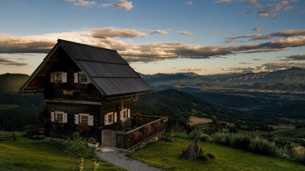 Solitude amidst Majestic Peaks: A Stunning HD Landscape Wallpaper featuring a Remote Mountain Retreat
