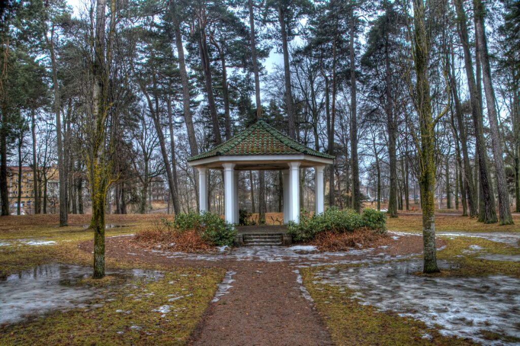 Serene spring park landscape with tall trees sparse foliage classic gazebo melting snow wallpaper