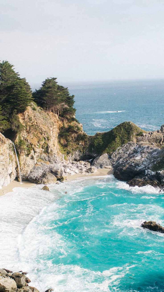 Serene Summer Beach Wallpaper: Turquoise Waters & Rocky Cliffs