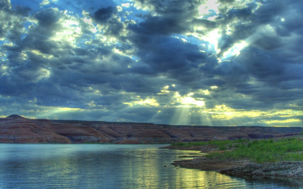 Serene summer river with dramatic clouds sun rays vibrant sky shimmering reflections calm water Wallpaper