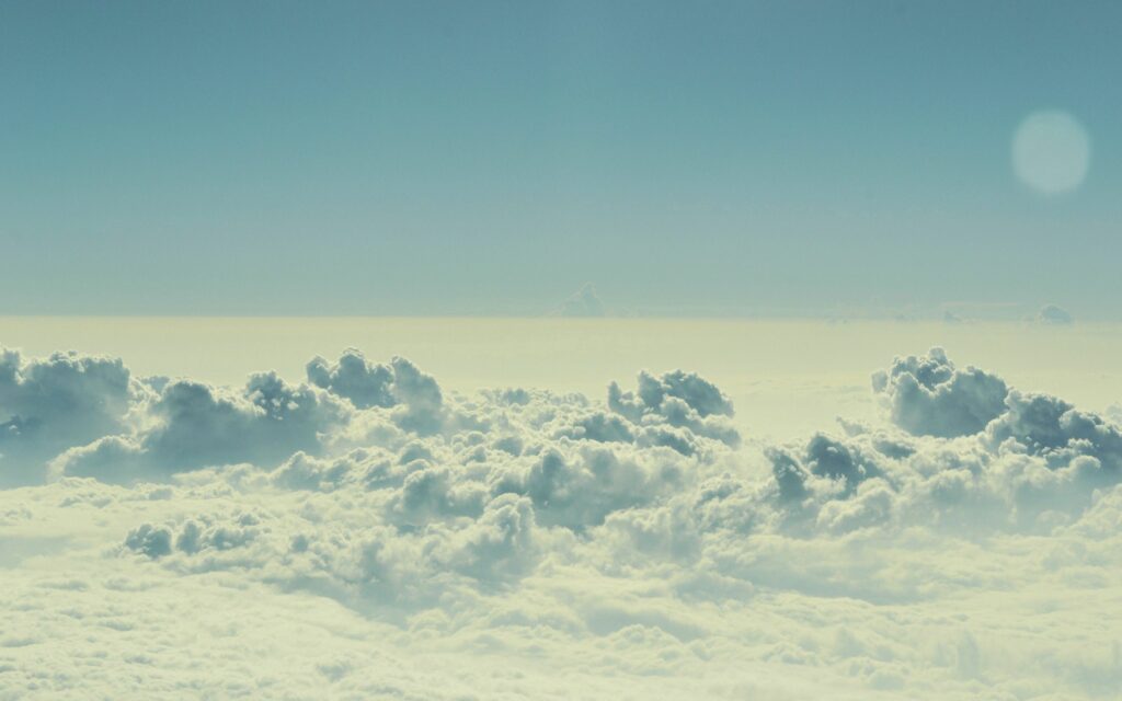 Serene summer sky with soft billowing clouds and gentle light creating a peaceful atmosphere Wallpaper