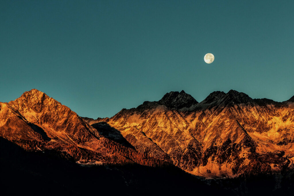 Serene Sunrise Over Rugged Mountains: Illuminated Wallpaper Background