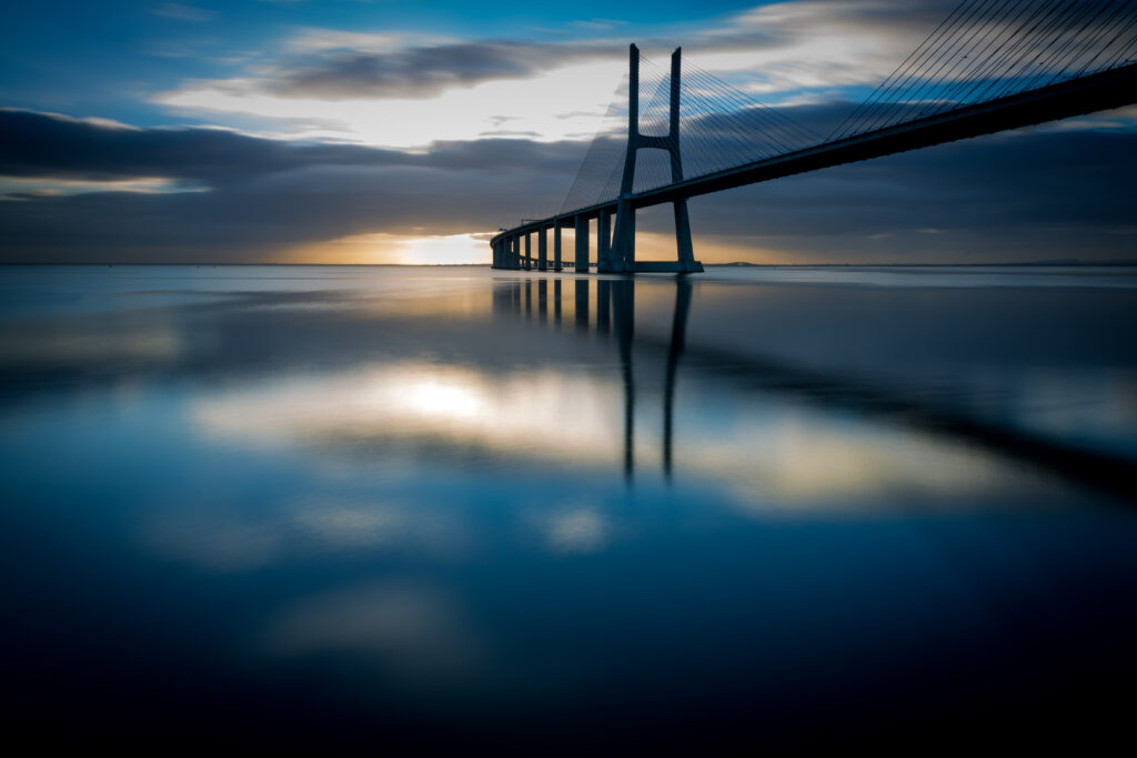 Serene Sunset Wallpaper: Stunning Bridge Over Calm Waters