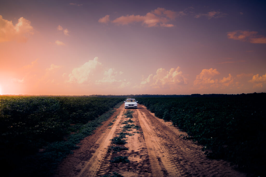Serene Sunset Drive: Rustic Dirt Road Car Wallpaper Background