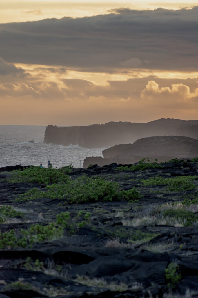 Sunset over rugged volcanic cliffs and serene shoreline with golden amber hues coastal wallpaper