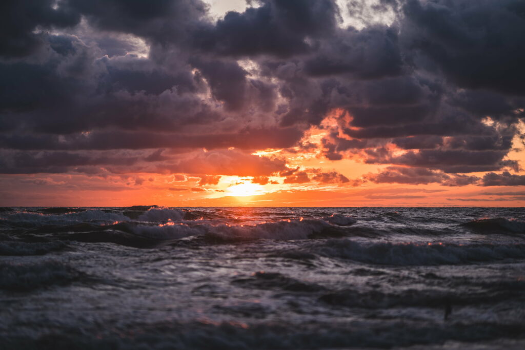 Serene Sunset Seascape: HD Wallpaper of Waves and Dramatic Clouds