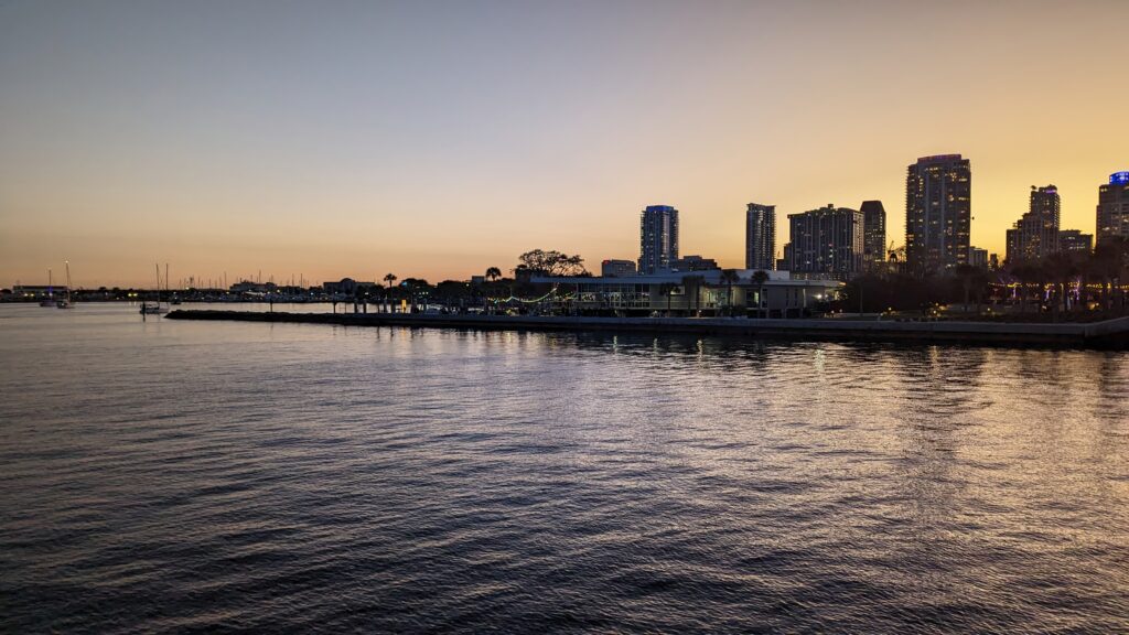 Serene Sunset Sea View Wallpaper with City Skyline & Pier
