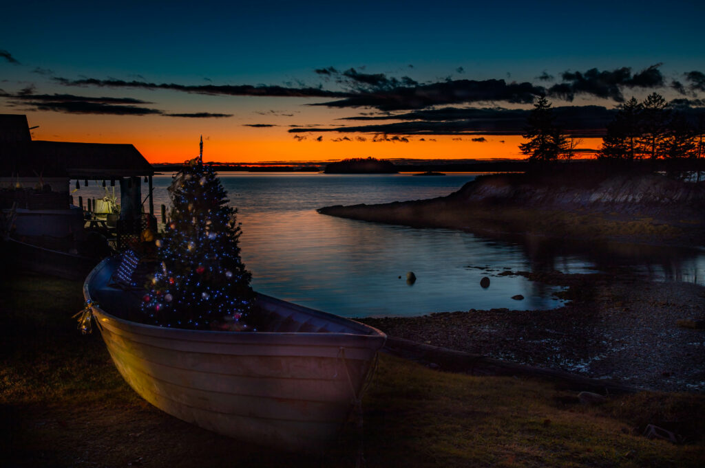 Serene Sunset River Scene with Festive Christmas Tree Background Wallpaper