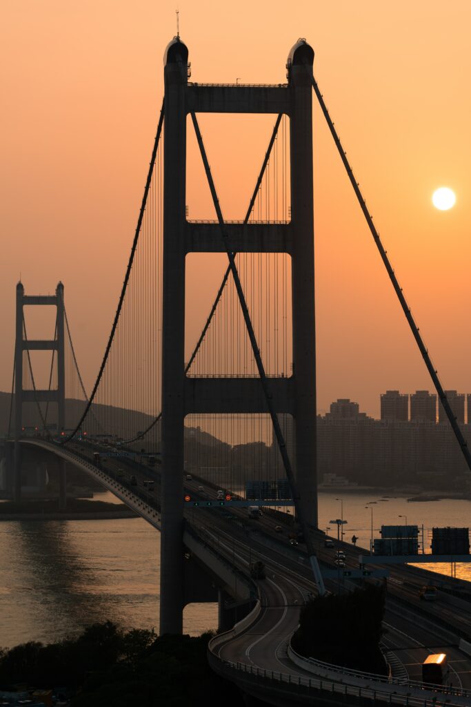 Serene Sunset Wallpaper: Suspension Bridge Over Tranquil River