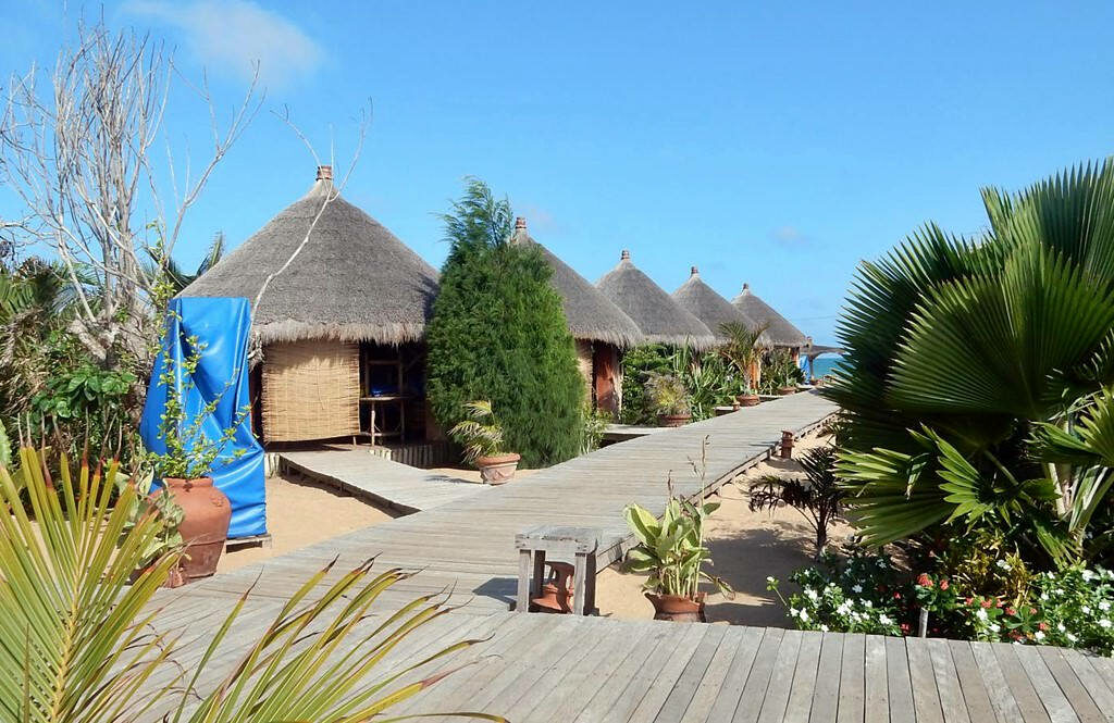 Serene Togo Resort Wallpaper: Tropical Huts & Lush Greenery