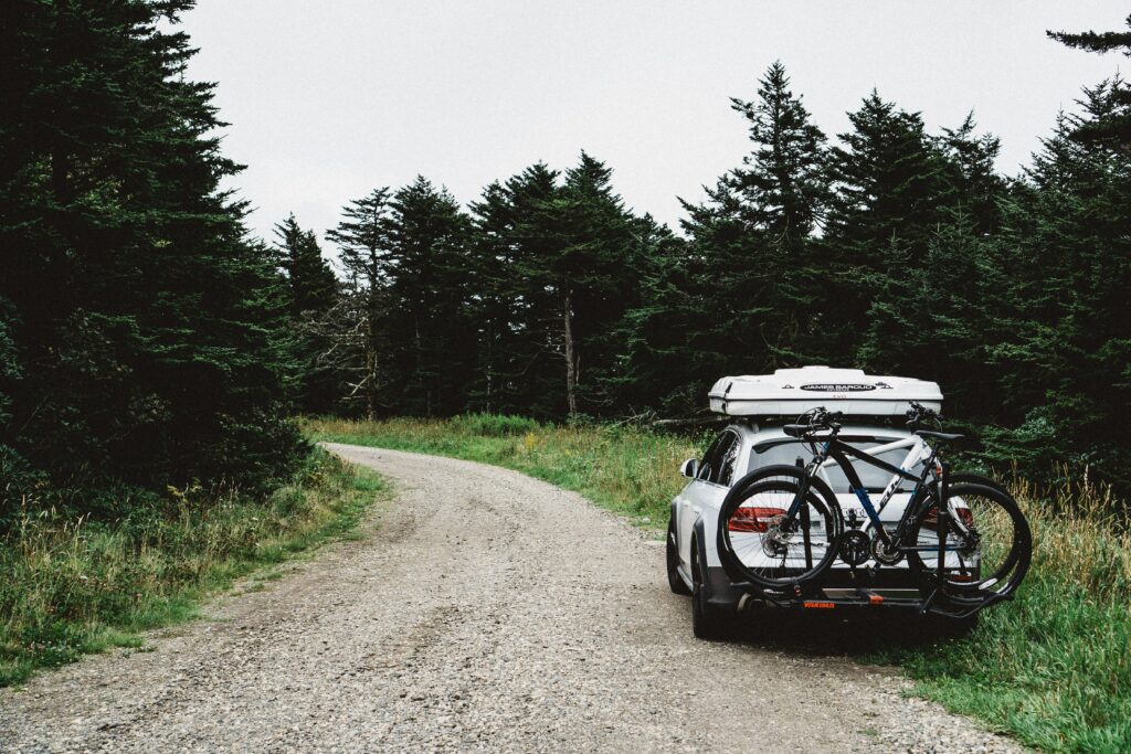 Scenic Travel Wallpaper: Car & Bike on Winding Gravel Road