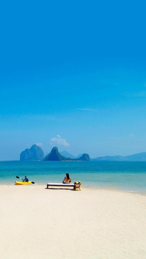 Serene Tropical Beach Wallpaper: Woman Relaxing by Turquoise Waters