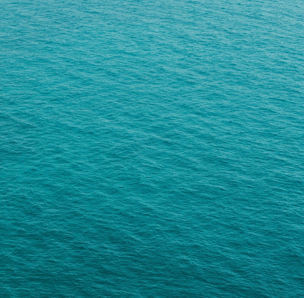 Tranquil turquoise sea wallpaper with gentle ripples minimalist calming blue green background