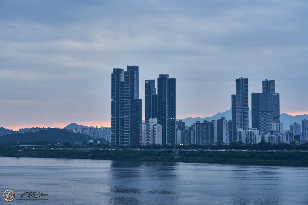 Serene Twilight Cityscape Wallpaper with Modern Buildings & Hills
