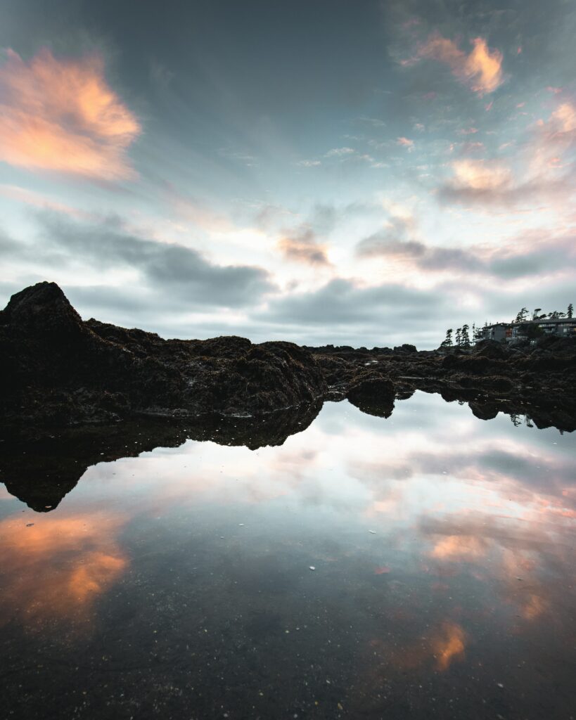 Serene twilight lake reflecting rugged hills and orange pink clouds peaceful dusk wallpaper