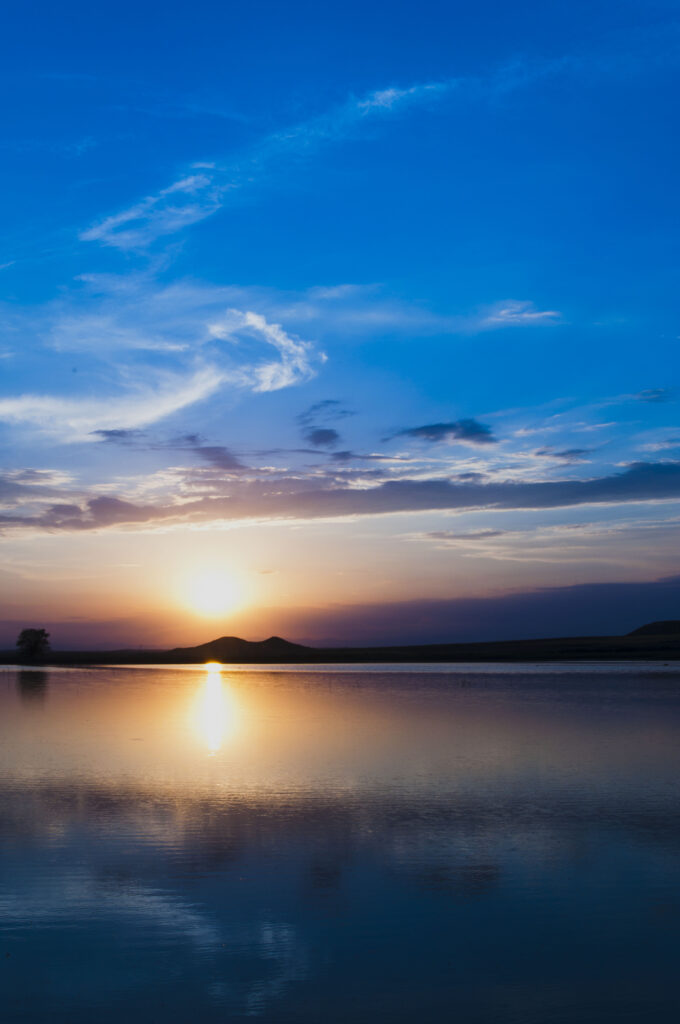 Serene twilight sunset over calm sea with vivid blue orange purple sky reflection wallpaper background