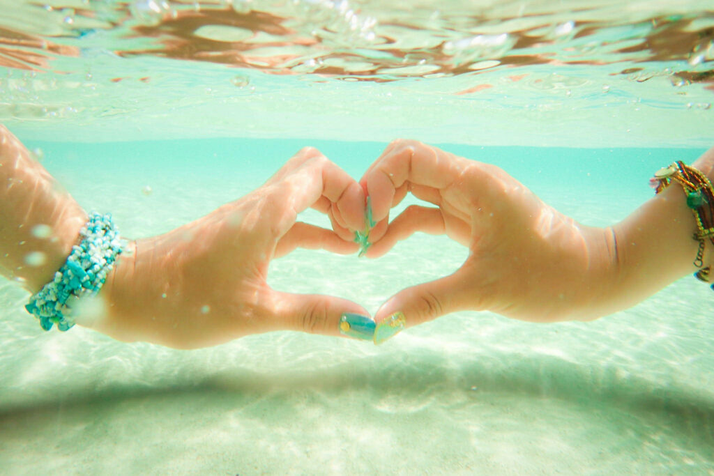 Tranquil Underwater Wallpaper: Heart-Shaped Hands in Turquoise Water