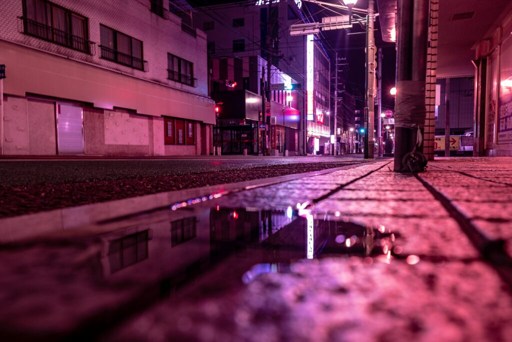 Serene Urban Night Wallpaper: Neon Lights & Reflective Puddles