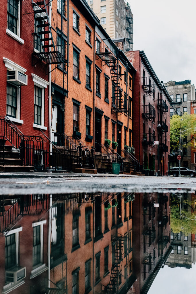 Charming Urban Brick Buildings Reflected in Puddle - Wallpaper Background