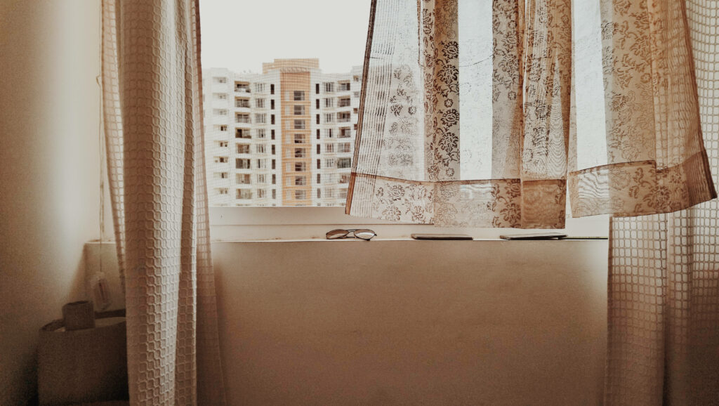 Peaceful Urban Wallpaper: Window View with Lace Curtains & Bright Sky