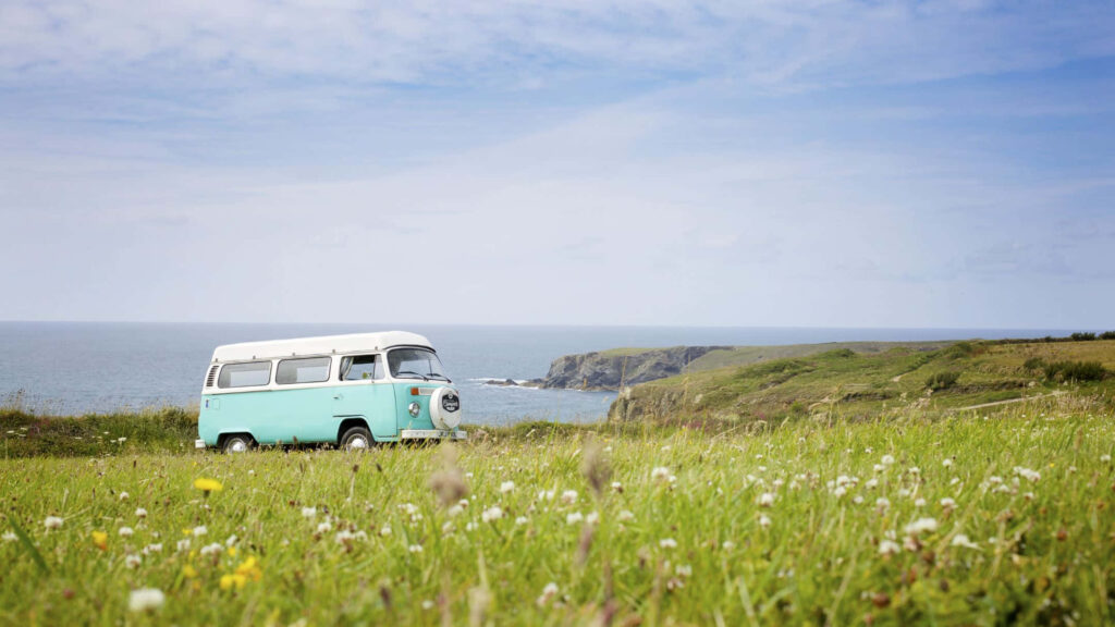 Serene Vintage Volkswagen Bus Wallpaper: Ocean Cliff Adventure