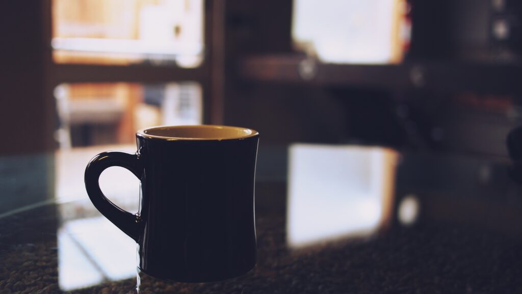 Calming Indoor Wallpaper: Black Cup on Reflective Table Background