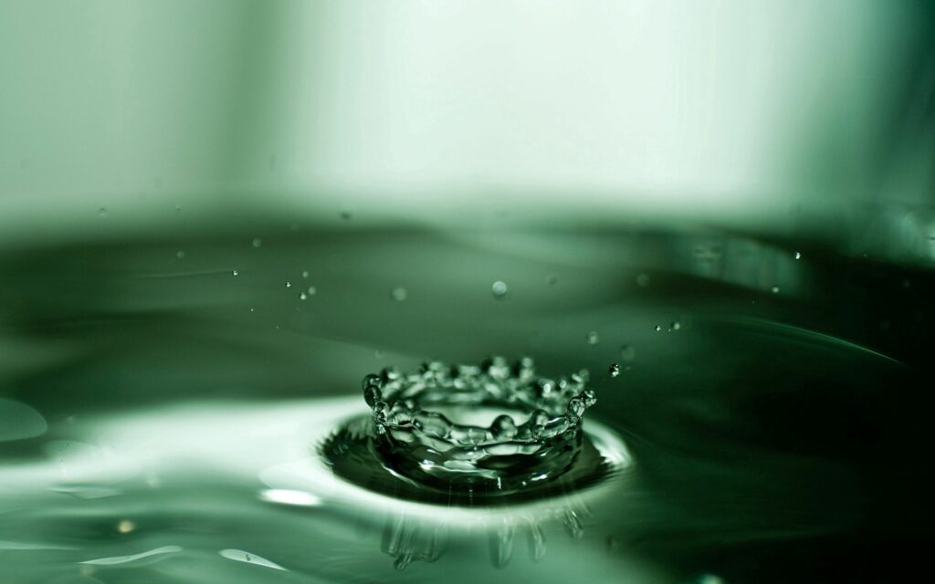 Serene Droplet Ripples on Calm Green Liquid - Wallpaper Background