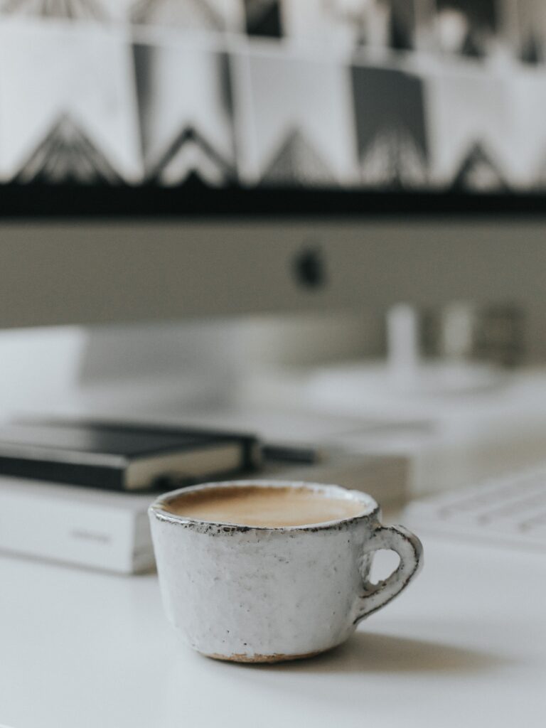 Cozy Cappuccino Wallpaper: Rustic Cup on Clean White Workspace